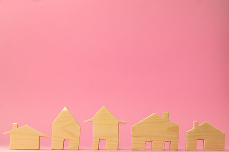 Wooden house miniature on pink background close upの写真素材