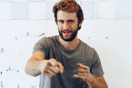 Pleased joyful bearded man against rough wallの写真素材