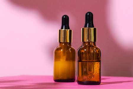 Skincare products containers on bright pink backgroundの写真素材