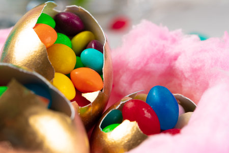 Egg shell with colorful candies inside in a decorative Easter nest