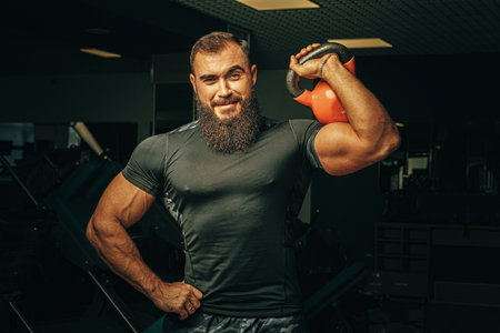 Bodybuilder doing exercises with dumbbells in a dark gymの写真素材