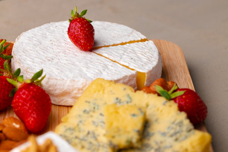 Composition of cheese, and fruits on gray table