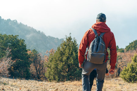 Man hiker walking in mountains with backpackの写真素材