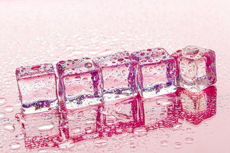 Fozen ice cubes on wet pink backgroundの写真素材