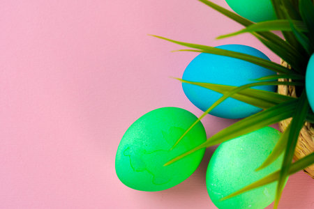 Colored eggs for Easter with pot of artificial grassの写真素材