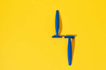 Studio shot of disposable razor tools on yellowの写真素材