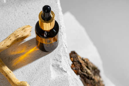 Glass jar of skincare serum on concrete blockの写真素材