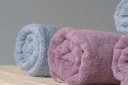 Pile of clean new towels against grey wall