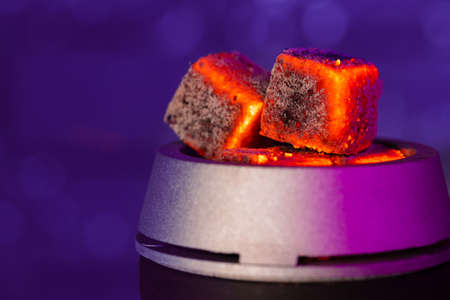 Burning hookah coals in hookah bowl close up