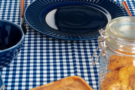 Classic blue ceramic tableware on checkered tableclothの写真素材