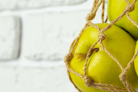 Ripe green apples in a light string bag