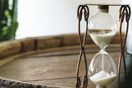 Sandglass on wooden bakground closeup. Time concept