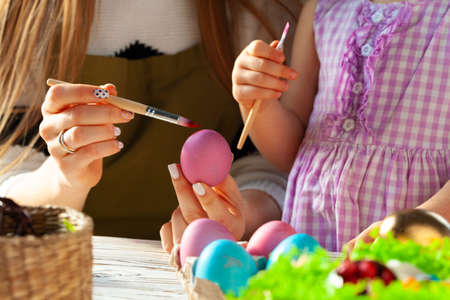 Mother and daughter coloring eggs for Easter