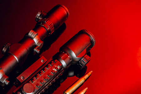 Optical scope for rifle on black background with red lightの写真素材
