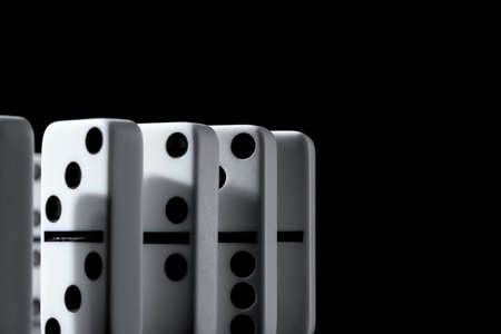 Dominoes standing in a row on black backgroundの写真素材