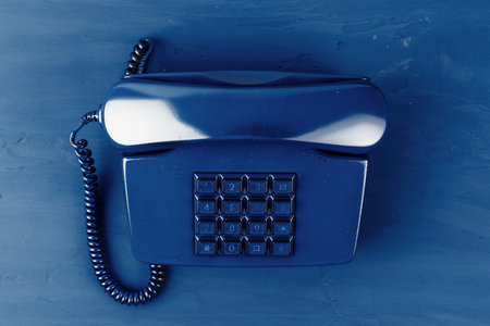 Retro telephone of blue color on classic blue background