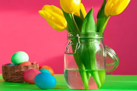 Vibrant colored eggs in a nest on green. Easter concept