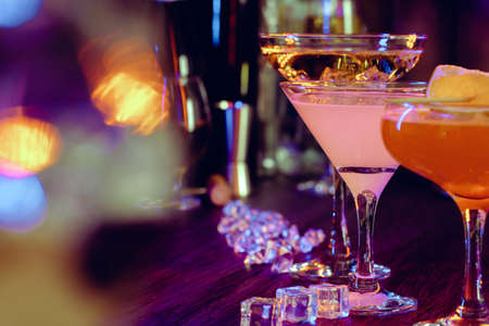Two beautiful cocktails served on a wooden bar counter