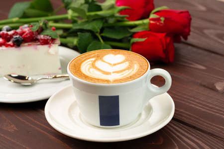 Cup of latte coffee with piece of berry cheesecakeの写真素材