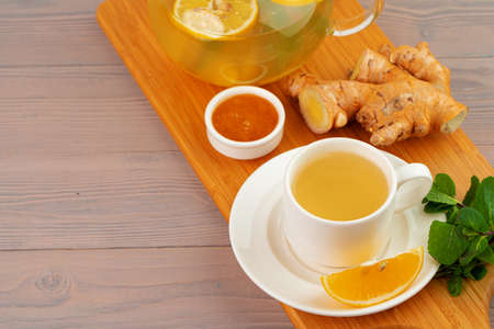 Cup of tea with ginger and mint on wooden tableの写真素材