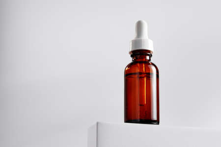 Essential oil bottle on gray block against gray backgroundの写真素材