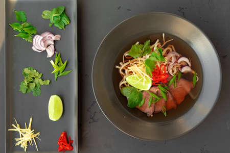 Asian soup Ramen with pork and noodles iserved on gray background