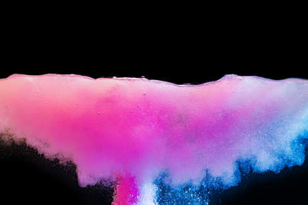 Pink bubbly boiling water against black background