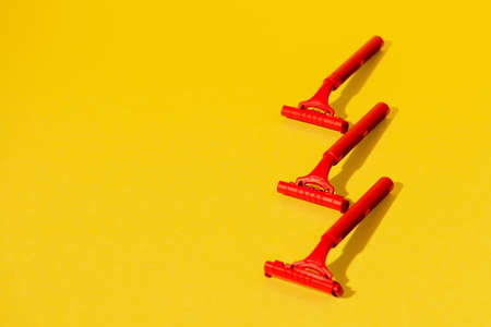 Disposable razors on yellow background, studio shotの写真素材
