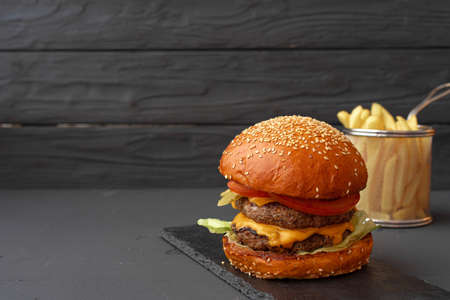 Fresh burger and fries on black wooden backgroundの写真素材