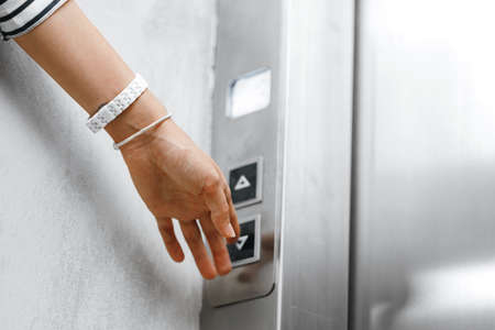 Female hand pushing the button of elevatorの写真素材