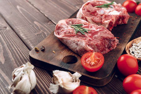 Raw meat beef shank slices on brown wooden boardの写真素材