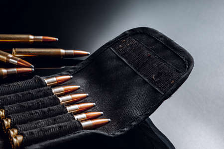 Rifle bullets or cartridges on black shiny background