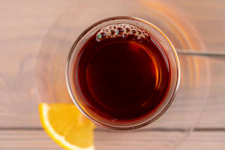 Turkish tea in glass cup with piece of lemon on wooden tableの写真素材