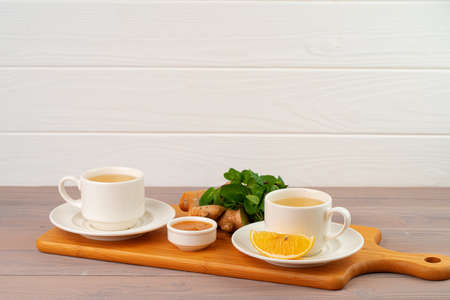 Cup of tea with ginger and mint on wooden tableの写真素材