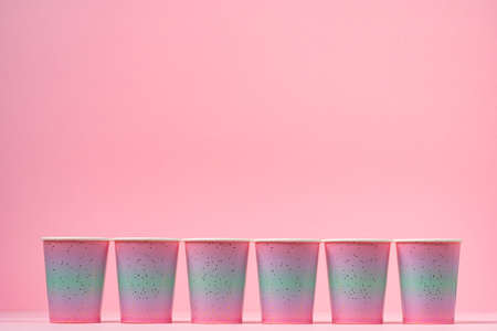 Pink disposable paper cups on pink backgroundの写真素材