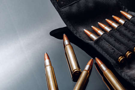 Rifle bullets or cartridges on black shiny background
