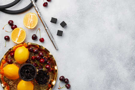 Hookah pipe and shaft with fruits on gray background