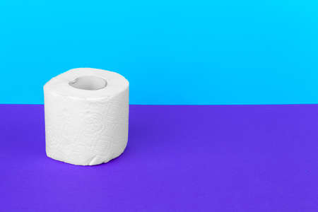 Toilet paper isolated on white table with blue background. Cleaning concept productの写真素材