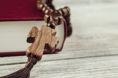 Bible and a crucifix on an old wooden table. Religion concept.