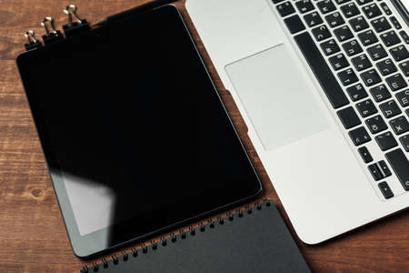 electronic gadgets and office supplies on wooden tableの写真素材