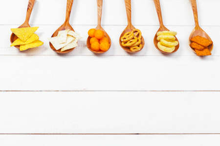 Mix of snacks : pretzels , crackers , chips and nachos on the tableの写真素材
