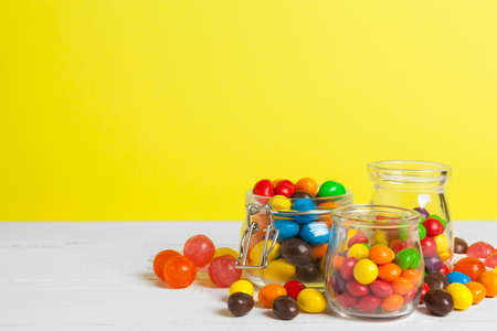 Bottles with sweet candies on table