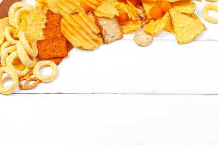 Mix of snacks : pretzels , crackers , chips and nachos on the tableの写真素材
