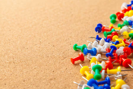Group of colorful push pins on cork bulletin boardの写真素材