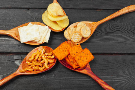 Mix of snacks : pretzels , crackers , chips and nachos on the tableの写真素材