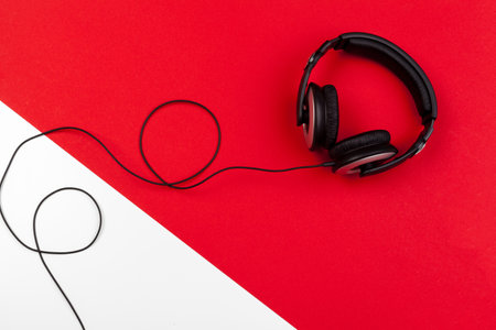Headphones with cord on red and white color backgroundの写真素材
