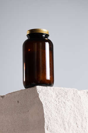 Glass jar with dietary supplement on cinder blockの写真素材