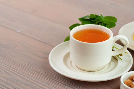 Cup of tea served with lemon and mintの写真素材