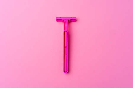 Single disposable razor on pink background top viewの写真素材