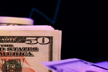 American dollar banknotes and graph on black backgroundの写真素材